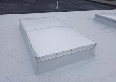 Świetlik płaski zamontowany na dachu płaskim hali produkcyjnej.